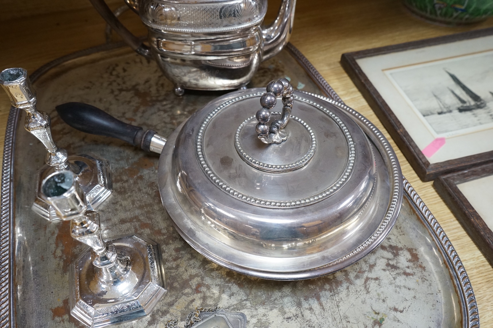 A pair of white metal candlesticks, a silver plated teapot circular tureen and cover spoons and forks and four spirit labels and large tray. Tray 73cm wide